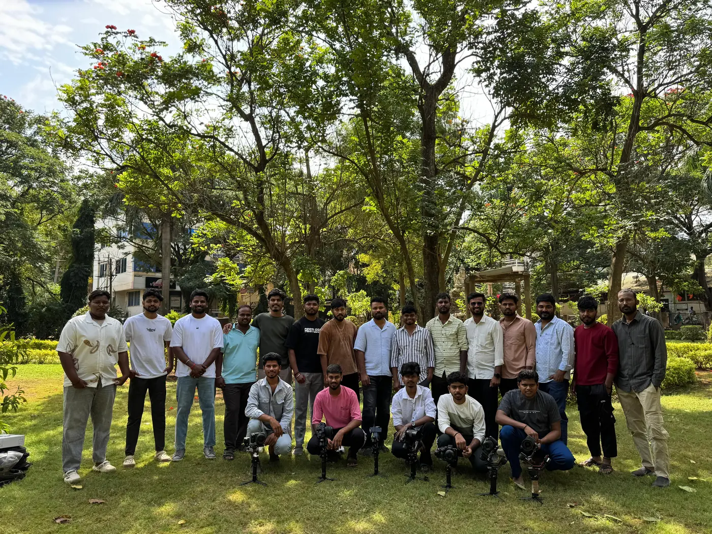 An SVM Photography batch standing together with their cameras and gimbals before an outdoor shoot